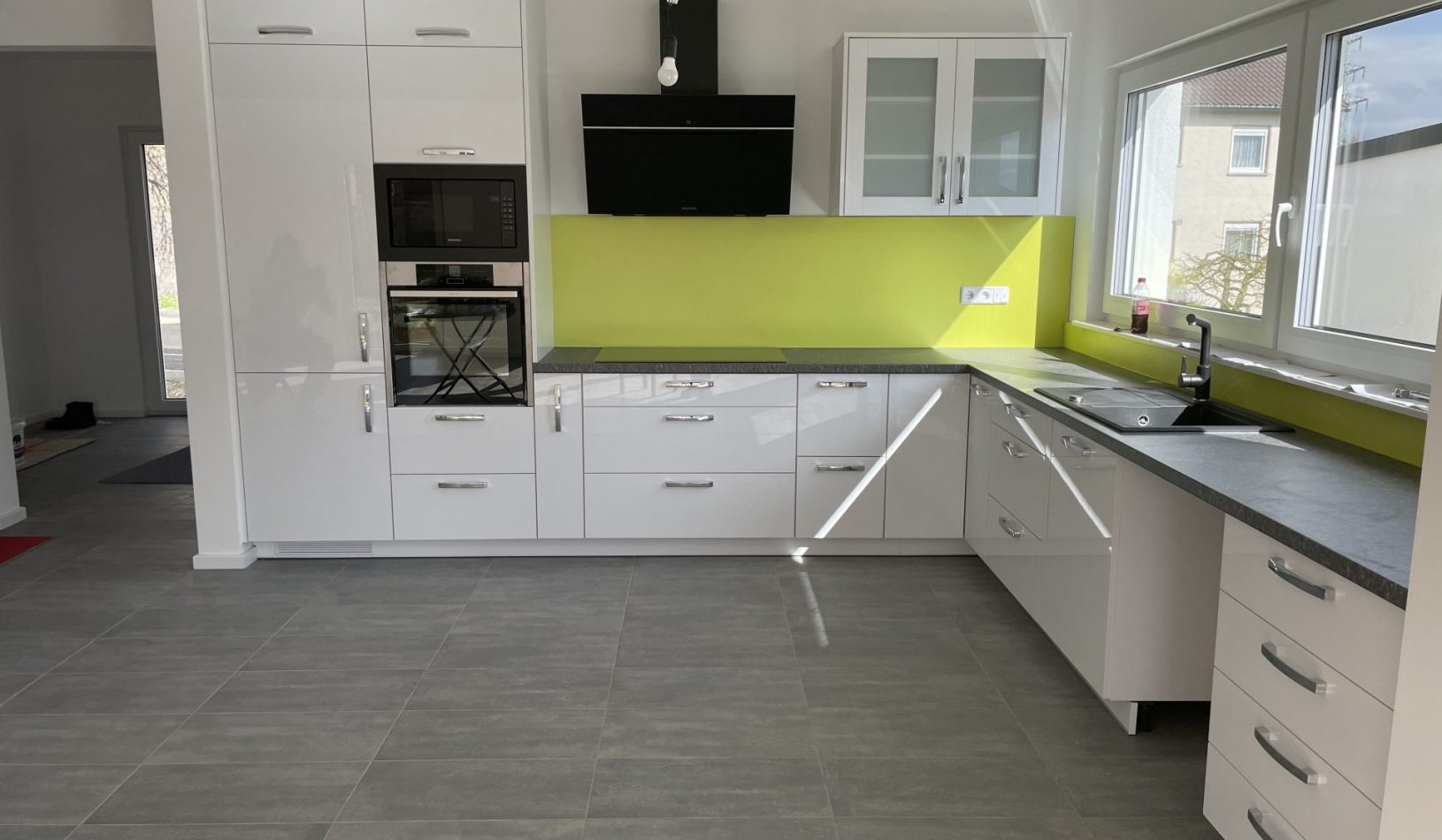 Projekt in Oberelchingen | L - Küche mit Backofen + Mikrowelle in Augenhöhe. Auf Kundenwunsch wurde mit der grünen Rückwand eine besonders Farbenfrohe Atmosphäre geschaffen.